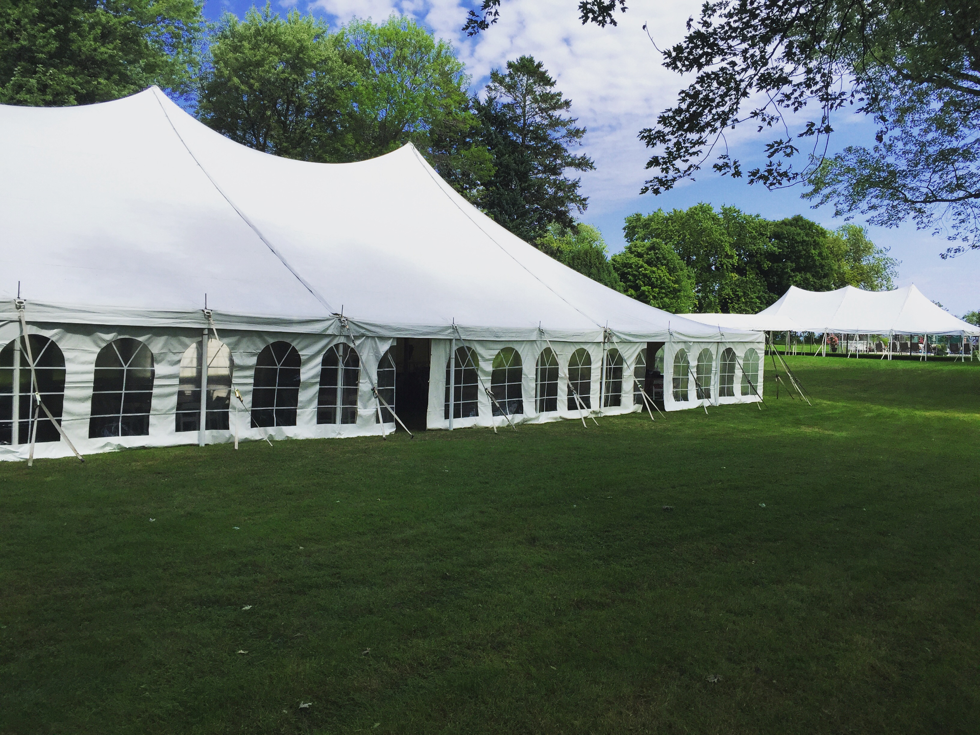Elegant white event tents on a green lawn, produced by Georgian Events
